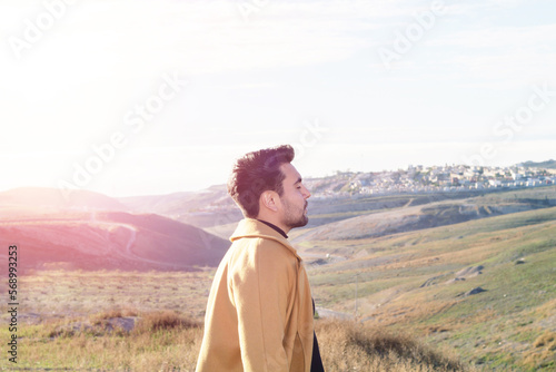 relaxed young mexican latino man enjoying nature with freedom face. elegant attractive hispanic model © cesar