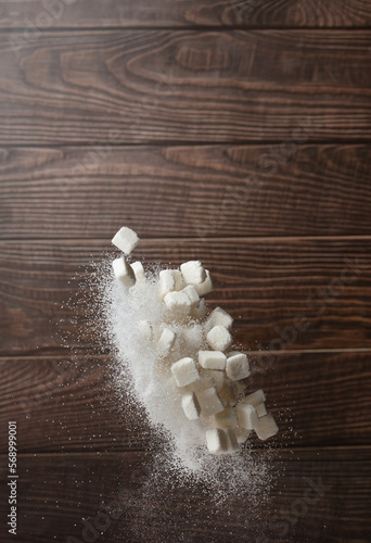Sugar Cube in sack bag flying explosion, white crystal sugar fall abstract fly. Pure refined sugar cubes bag splash in air, food object design. wood kitchen background, high speed freeze motion