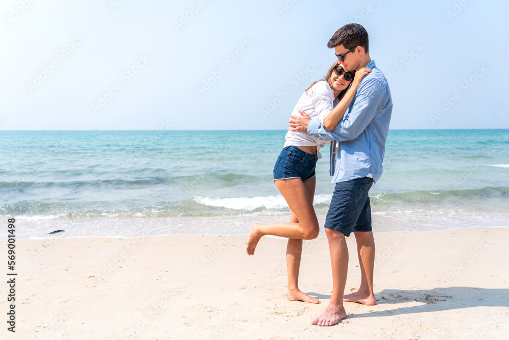 Vacation romantic love young happy smile couple in honeymoon travel holiday trip standing on sand at blue sky sea beach having fun and relaxing together on tropical beach.Summer travel Vacation romantic love young happy smile couple in honeymoon travel holiday trip standing on sand at blue sky sea beach having fun and relaxing together on tropical beach.Summer travel