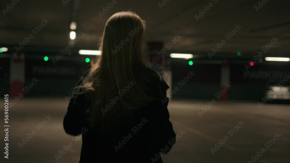 Frightened lonely woman behind view scared walking girl running alone in parking dark underground subway afraid caucasian female lady victim run from threat criminal chase moving fast turn head back