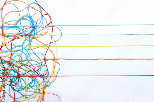 Kmitting colorful threads on a white background photo