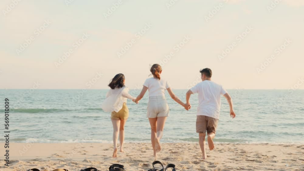Happy friends holding hands running enjoy life funny and freedom on sand at beach together to sea in holiday vacation time at sunset, Young Asian group woman and man in summer travel, people lifestyle Happy friends holding hands running enjoy life funny and freedom on sand at beach together to sea in holiday vacation time at sunset, Young Asian group woman and man in summer travel, people lifestyle