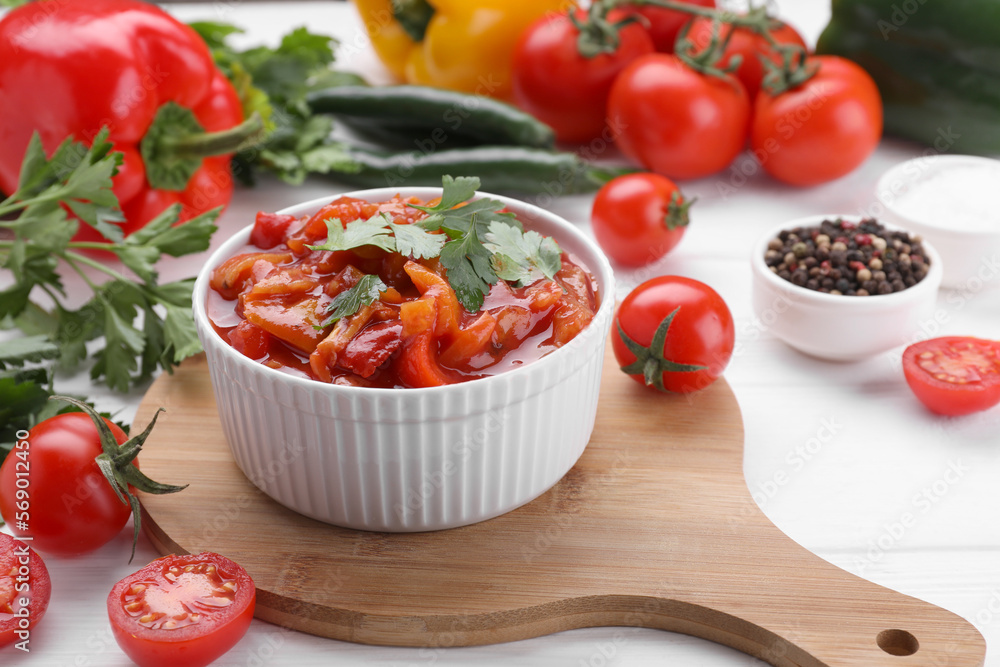Delicious lecho in bowl and fresh ingredients on white wooden table Delicious lecho in bowl and fresh ingredients on white wooden table