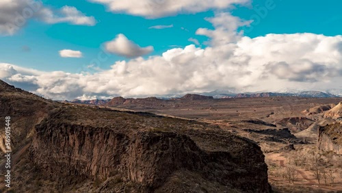 Billowing clouds over a rugged desert landscape - time lapse photo