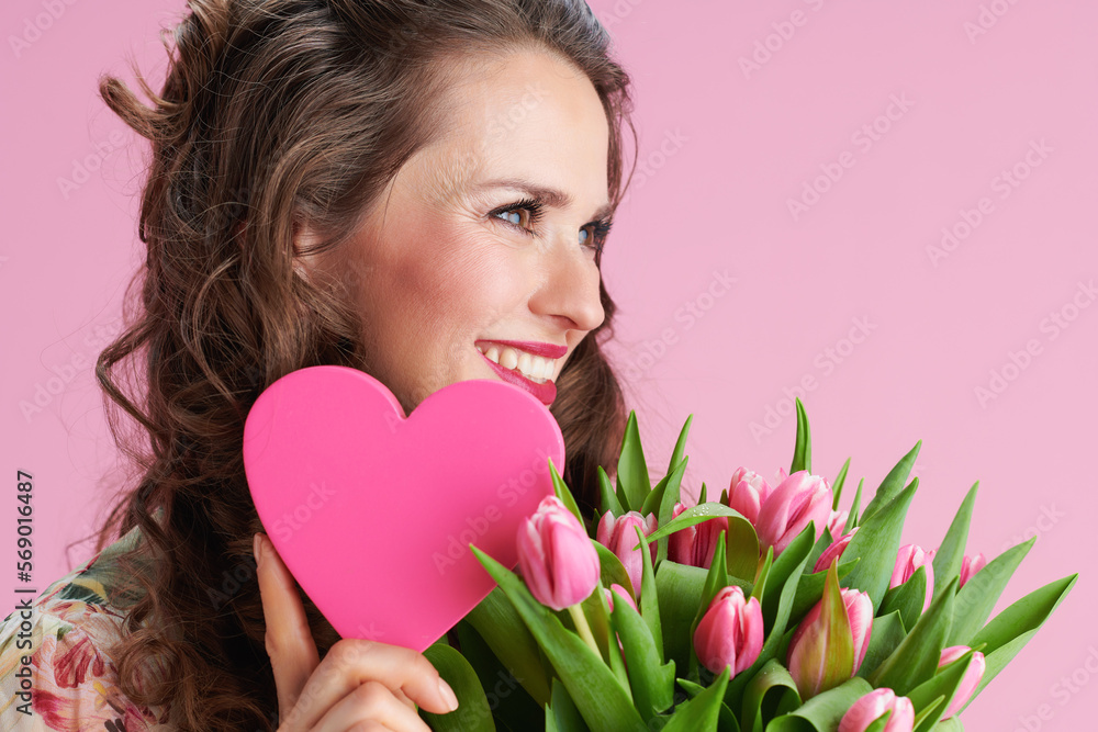 smiling trendy 40 years old woman in floral dress on pink smiling trendy 40 years old woman in floral dress on pink