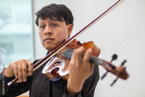 viola player, hispanic violinist or violist close up, young man playing viola. latin hispanic violin player playing viola or violin photo