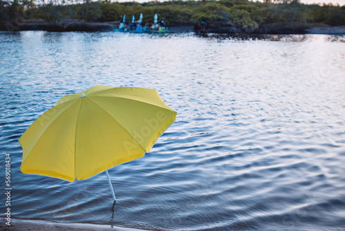 a yellow umbrella on the riverbank