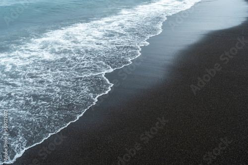 Fototapeta Naklejka Na Ścianę i Meble -  Black volcanic sand on the beach with waves.
