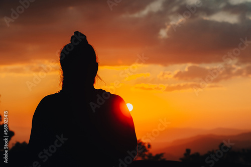 silhouette young woman is looking at the sunset.