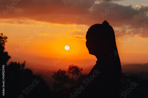 silhouette young woman is looking at the sunset.