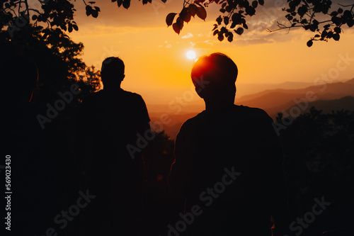 silhouette achievements successful man is on top of hill celebrating success with sunset