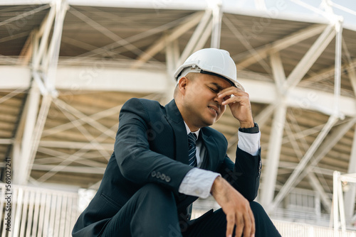 Depressed fail Businessman manager owner real estate. Sitting at stair office building. Stressed serious man of architect designer. Engineer with helmet has problem with working construction site
