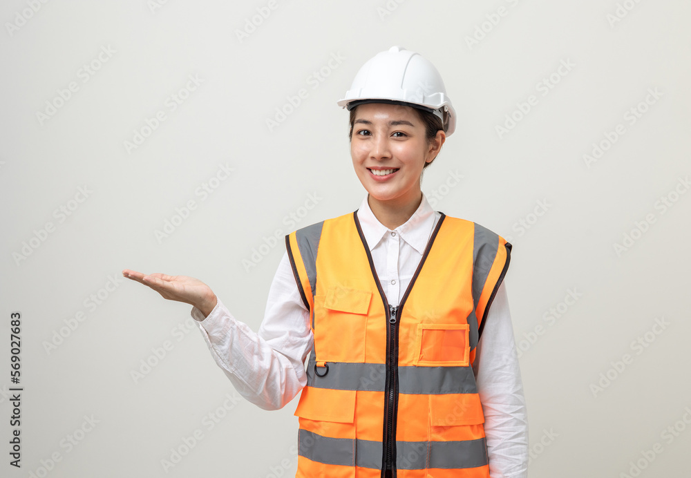 Asian engineer worker woman or architect with white safety helmet standing on isolated white background. Mechanic service factory Professional work job occupation in uniform pointing finger to space Asian engineer worker woman or architect with white safety helmet standing on isolated white background. Mechanic service factory Professional work job occupation in uniform pointing finger to space