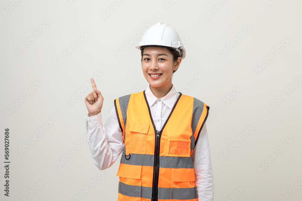 Asian engineer worker woman or architect with white safety helmet standing on isolated white background. Mechanic service factory Professional work job occupation in uniform pointing finger to space Asian engineer worker woman or architect with white safety helmet standing on isolated white background. Mechanic service factory Professional work job occupation in uniform pointing finger to space