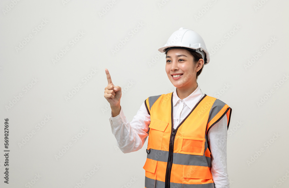 Asian engineer worker woman or architect with white safety helmet standing on isolated white background. Mechanic service factory Professional work job occupation in uniform pointing finger to space Asian engineer worker woman or architect with white safety helmet standing on isolated white background. Mechanic service factory Professional work job occupation in uniform pointing finger to space
