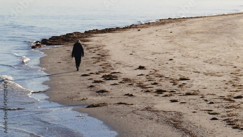 Man Walks Alone on Beach in Semaphore During a Winter Morning photo