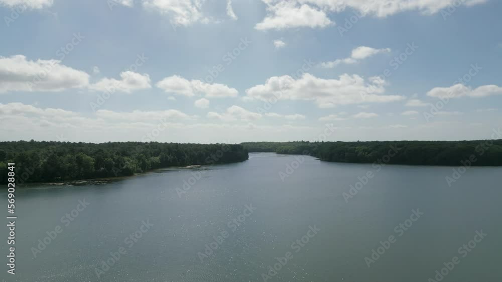 Lake of Tremelin crossing green forest, Brocéliande in Brittany, France. Aerial forward Lake of Tremelin crossing green forest, Brocéliande in Brittany, France. Aerial forward
