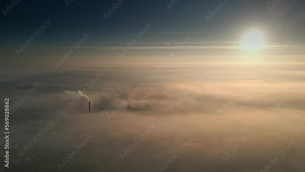 Aerial Drone scene above the Urban townscape areas shrouded In thick morning mist. Warm morning sunlight Aerial Drone scene above the Urban townscape areas shrouded In thick morning mist. Warm morning sunlight