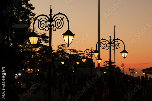 Night view of The Ridge Christ Church and shopping street in Mall Road Shimla. Vintage old street lamp post. Street light shining at night against sunset in Capital of Himachal Pradesh north India. photo