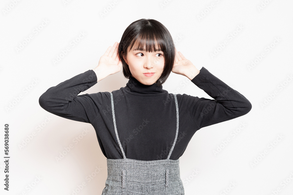 聞き耳を立てている若い女性