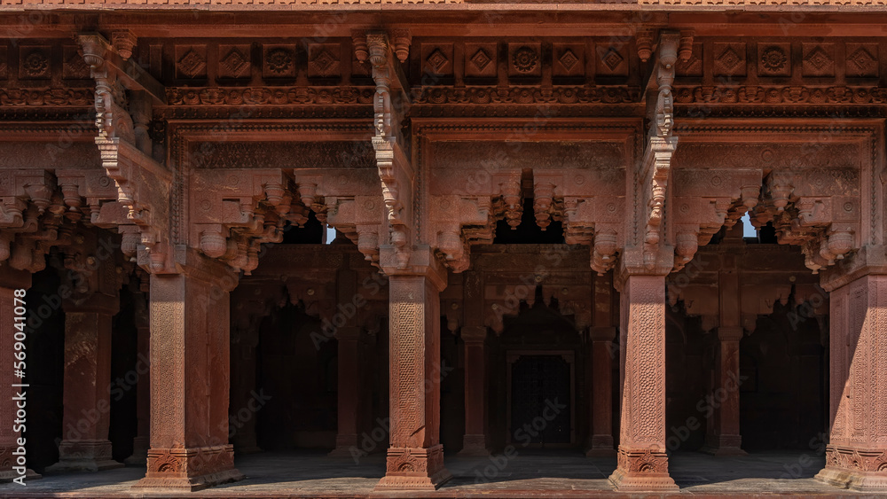 The architecture of the ancient Red Fort. Colonnade with openwork carved arches. Ornaments and patterns on walls and columns. India. Agra. The architecture of the ancient Red Fort. Colonnade with openwork carved arches. Ornaments and patterns on walls and columns. India. Agra.