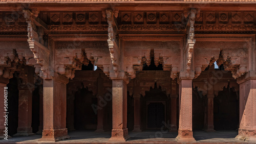 The architecture of the ancient Red Fort. Colonnade with openwork carved arches. Ornaments and patterns on walls and columns. India. Agra.