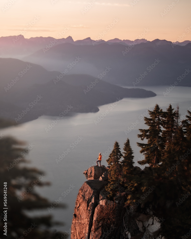 girl standing on a mountain peak looking at the scenery 