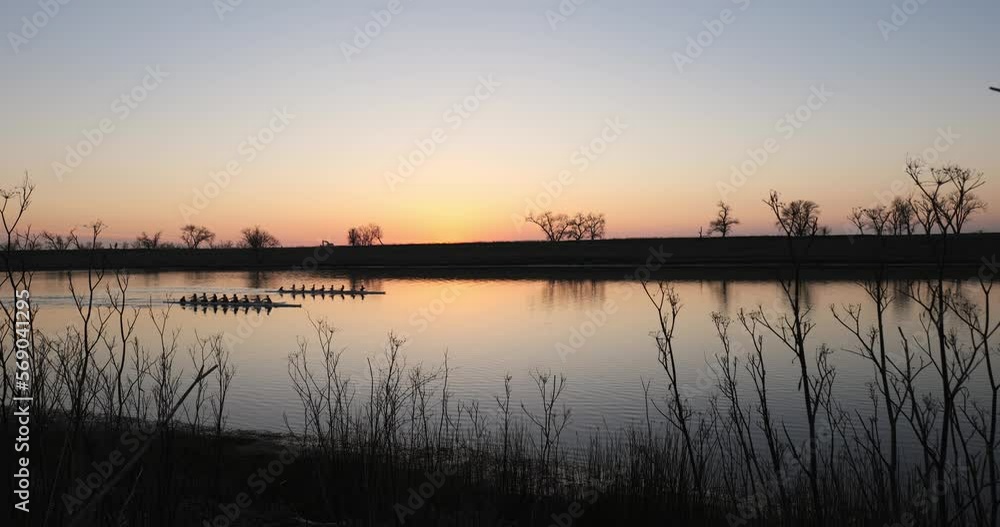 Silhouette of crew rowers at sunset on river Silhouette of crew rowers at sunset on river