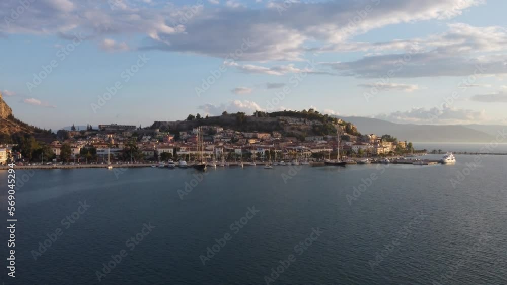 Aerial view of the picturesque Mediterranean town of Nauplio in the Peloponnese region of Greece, during a cloudy afternoon with yachts in port | 4K Aerial view of the picturesque Mediterranean town of Nauplio in the Peloponnese region of Greece, during a cloudy afternoon with yachts in port | 4K