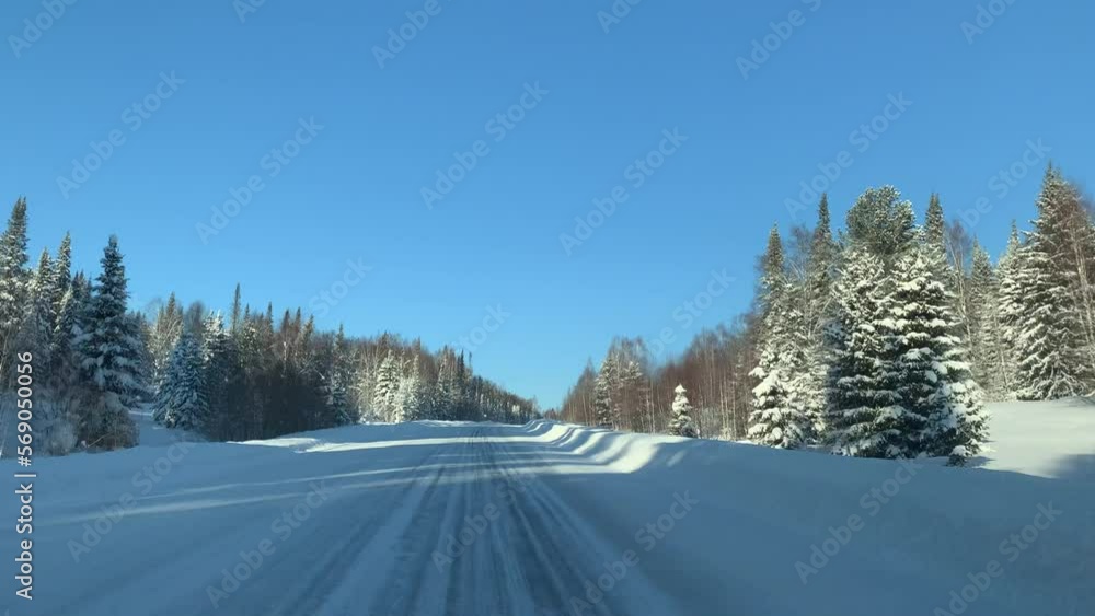 Driving a car on a winter road through a snow-covered forest. Beautiful and dangerous driving on a winter road. Driving a car on a winter road through a snow-covered forest. Beautiful and dangerous driving on a winter road.