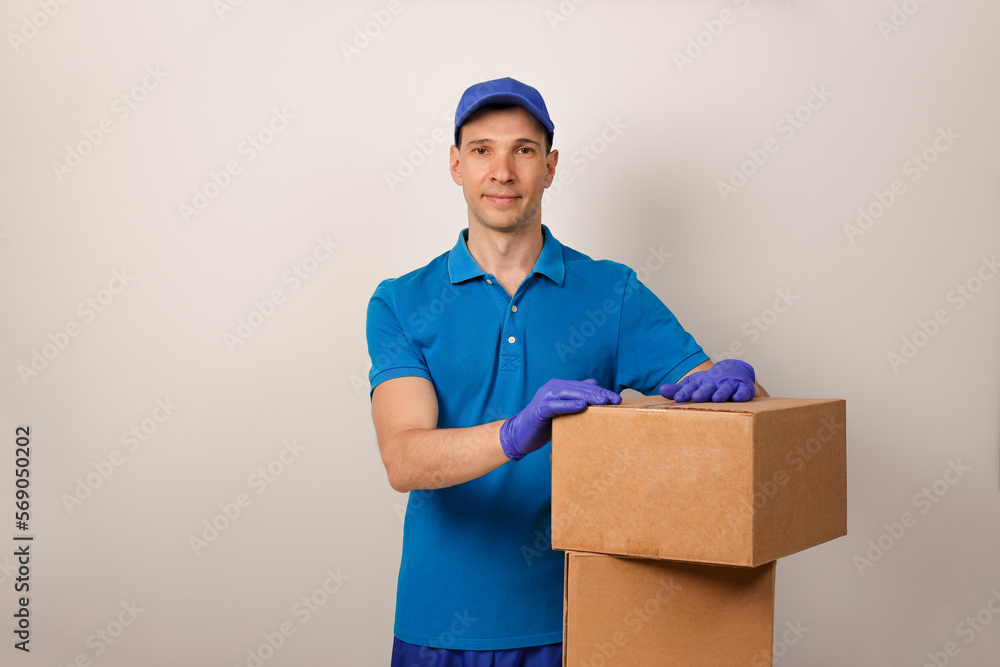 Portrait of handsome attractive cheerful delivery man holding card-board box. Express delivery service. Copy space. Portrait of handsome attractive cheerful delivery man holding card-board box. Express delivery service. Copy space.