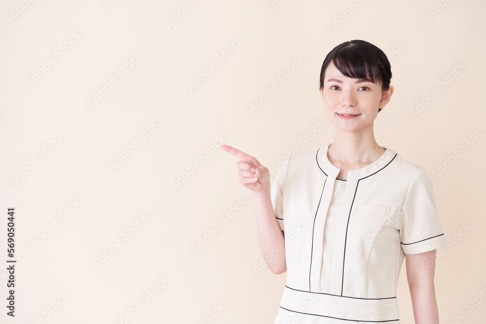 指で指し示すエステ・美容クリニックの女性 指で指し示すエステ・美容クリニックの女性