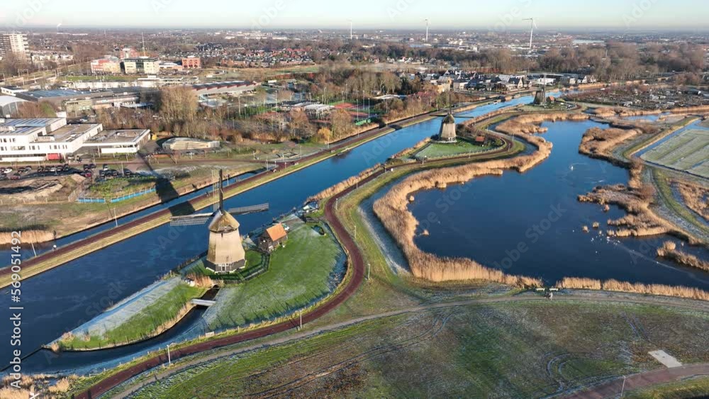 Typical dutch historic folklore windmill culture in winter time. Ice, sun, lake, canals, aerial. Overhead panorama view. Holland, The Netherlands. Typical dutch historic folklore windmill culture in winter time. Ice, sun, lake, canals, aerial. Overhead panorama view. Holland, The Netherlands.