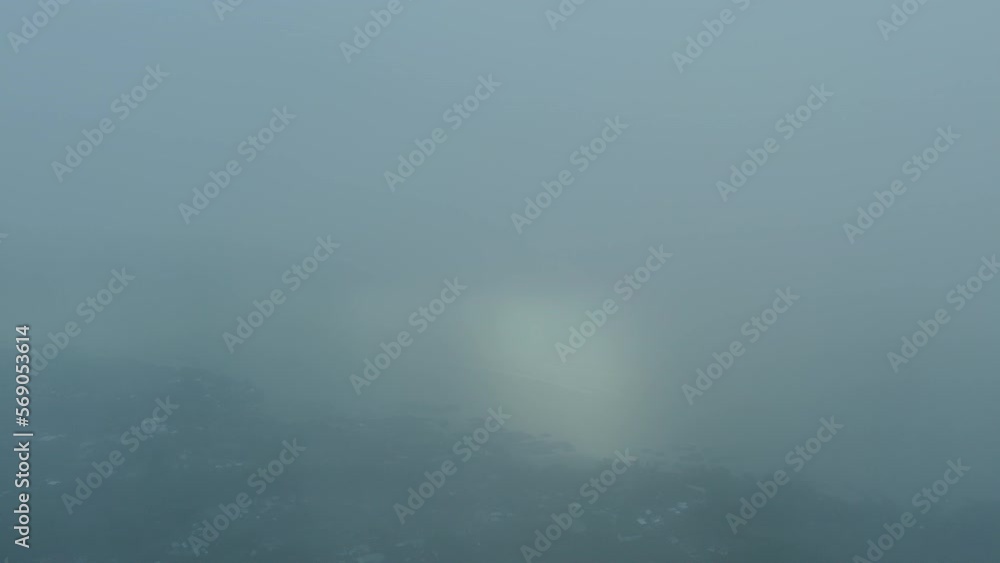 Foggy early morning in sunrise with fog, mist. Drone flying through the cloud. Aerial view of village located on the lake coast. Cool cold cinematic colors Foggy early morning in sunrise with fog, mist. Drone flying through the cloud. Aerial view of village located on the lake coast. Cool cold cinematic colors