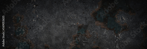 Dark wide panoramic background. Peeling paint on a concrete wall. Dark grunge texture of old cracked flaking paint. Weathered rough painted surface. Patterns of cracks. Darkness background for design. © Andrei Stepanov
