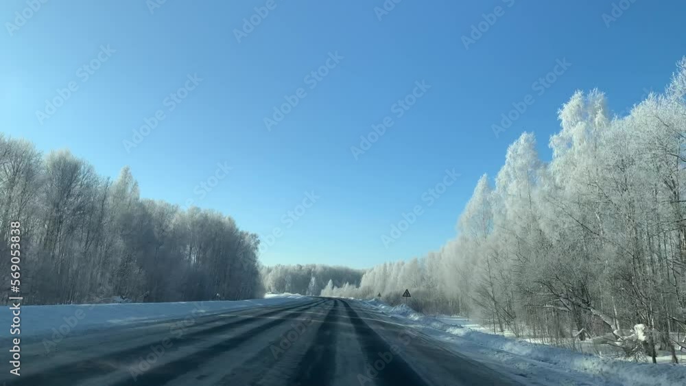Driving a car on a winter road through a snow-covered forest. Beautiful and dangerous driving on a winter road. Driving a car on a winter road through a snow-covered forest. Beautiful and dangerous driving on a winter road.