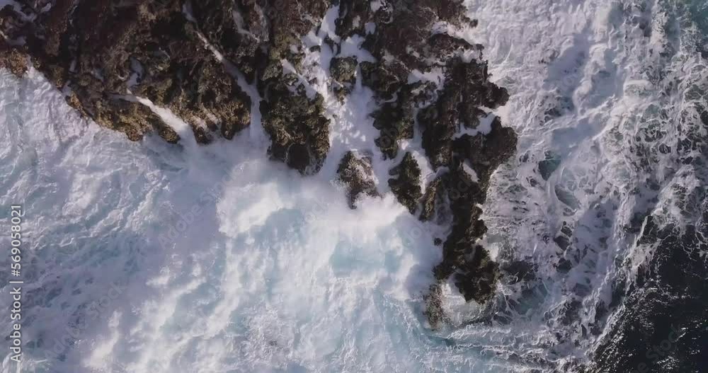 Harsh and aggressive waves crashing violently over sea stacks in oahu west honolulu hawaii explosive crashes of white sea foam, AERIAL TOP DOWN STATIC Harsh and aggressive waves crashing violently over sea stacks in oahu west honolulu hawaii explosive crashes of white sea foam, AERIAL TOP DOWN STATIC