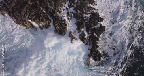 Harsh and aggressive waves crashing violently over sea stacks in oahu west honolulu hawaii explosive crashes of white sea foam, AERIAL TOP DOWN STATIC photo