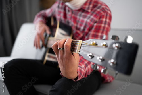 Close up male musician hands playing acoustic guitar.