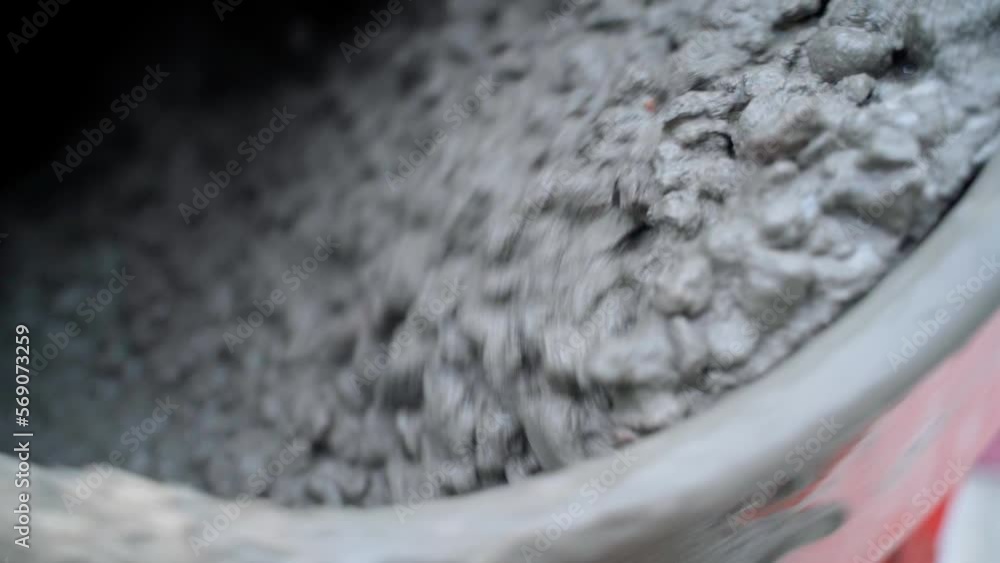 A concrete mixer mixes cement mortar with small gravel closeup in slow