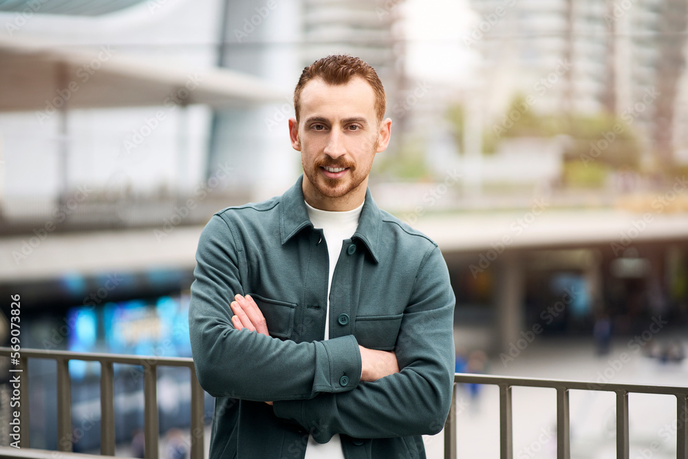 Portrait of smiling confident man with arms crossed in stylish casual clothing looking at camera Portrait of smiling confident man with arms crossed in stylish casual clothing looking at camera