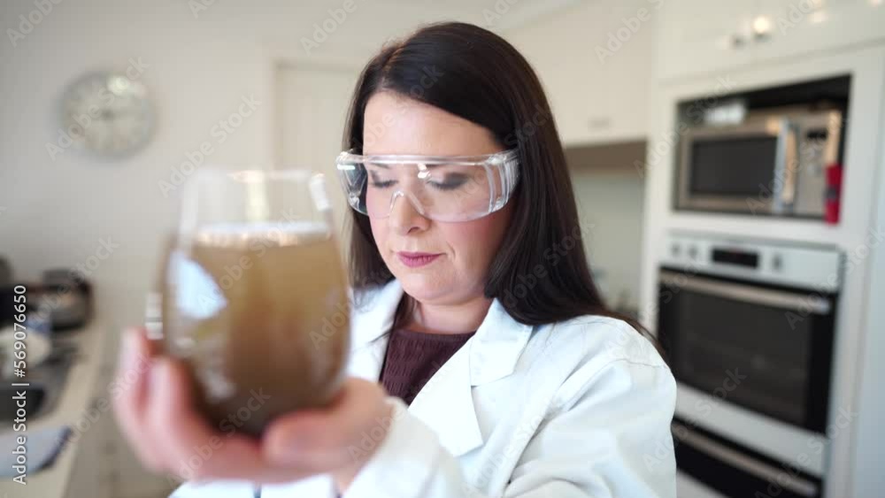 young girl in a soil laboratory in a lab coat and safety glasses testing a sample young girl in a soil laboratory in a lab coat and safety glasses testing a sample