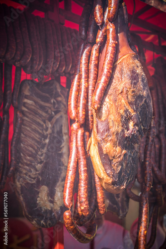 Dry meat and sausages hanging at the outdoor market stall photo