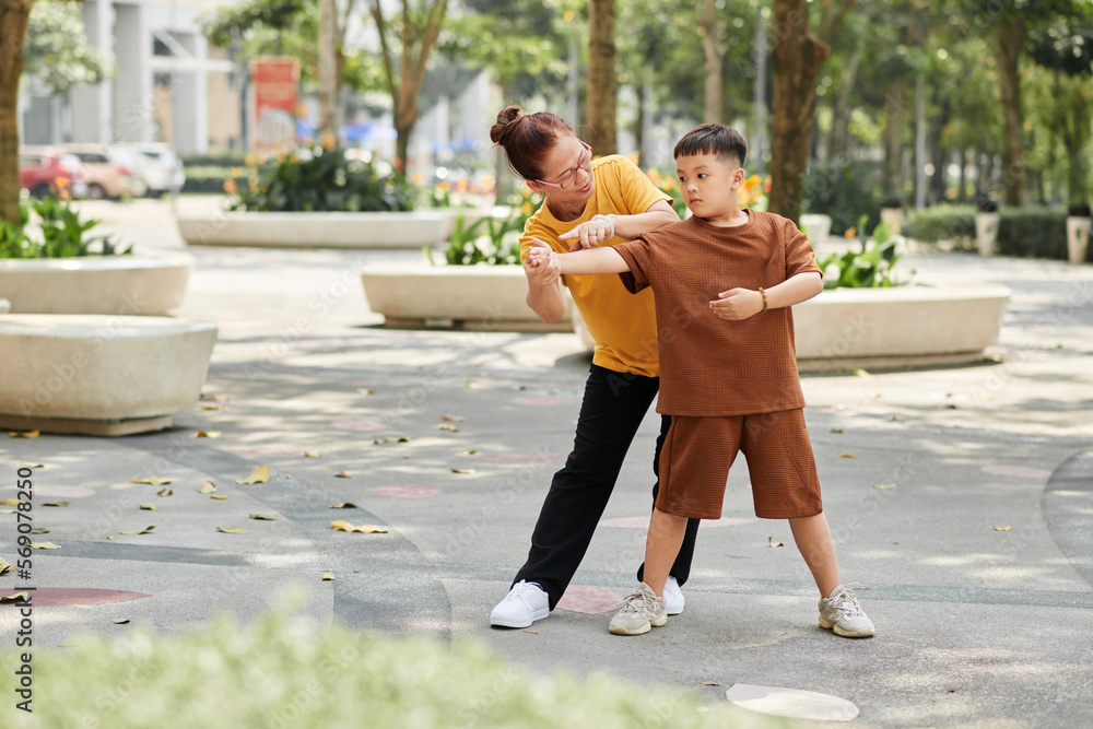 Obraz premium Senior Woman Teaching Boy Exercise