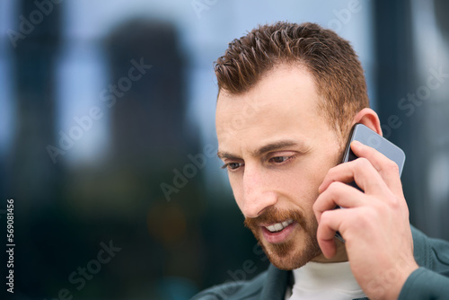 Closeup portrait of handsome smiling man talking on mobile phone on the street. Technology concept