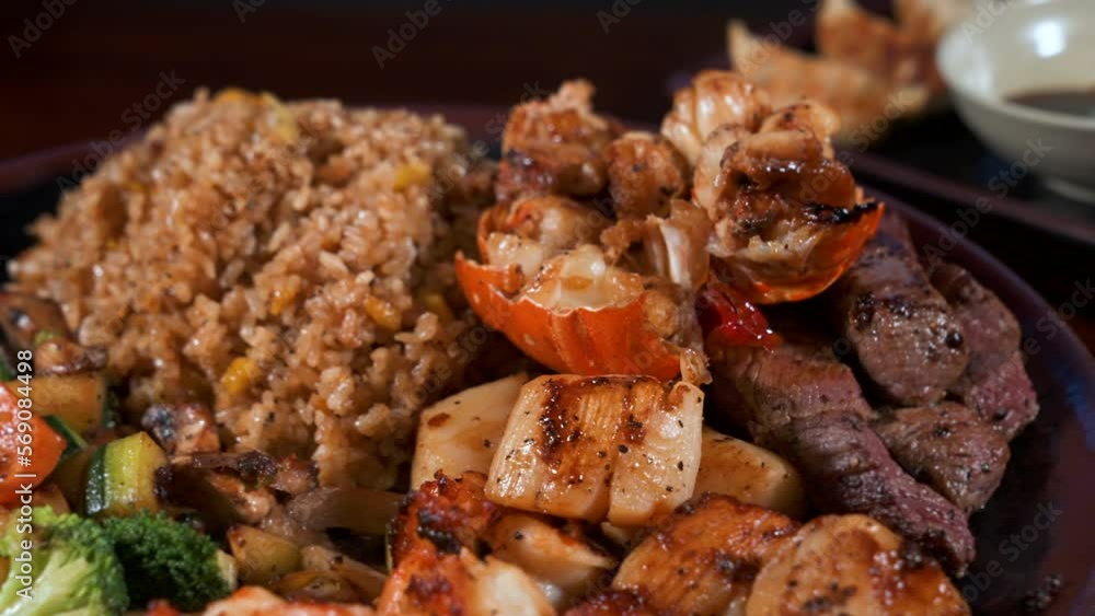 Surf and turf hibachi plate, mixed proteins lobster steak scallops shrimp fried rice mixed vegetables, slider close up 4K Surf and turf hibachi plate, mixed proteins lobster steak scallops shrimp fried rice mixed vegetables, slider close up 4K