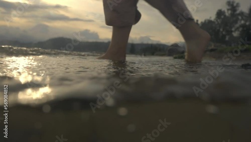 Girl walking into the lake barefoot photo