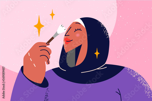 Smiling woman in hijab doing makeup 
