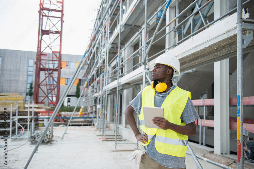 Construction worker holding digital tablet at building site Construction worker holding digital tablet at building site
