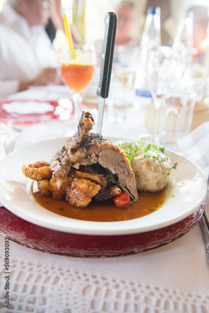 Roasted duck with bread dumpling on plate at restaurant table, Bavaria, Germany Roasted duck with bread dumpling on plate at restaurant table, Bavaria, Germany